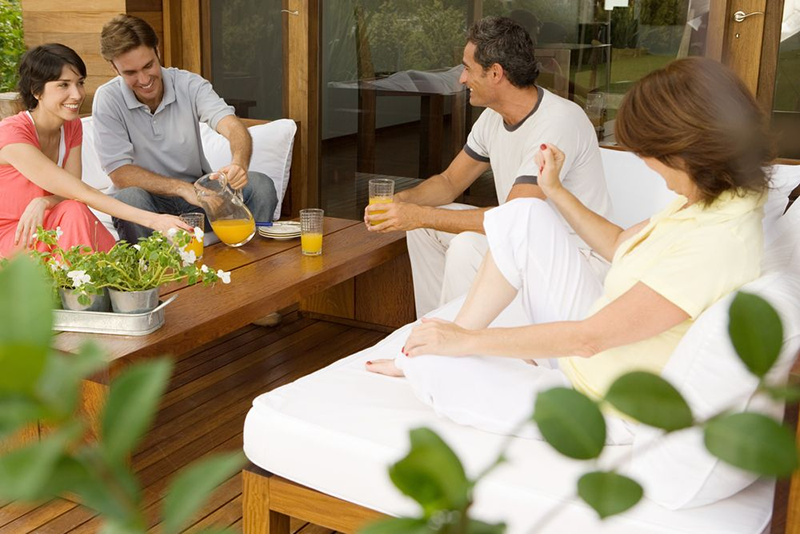 Group of people gathering on Teak Outdoor Sofa https://liveouter.com