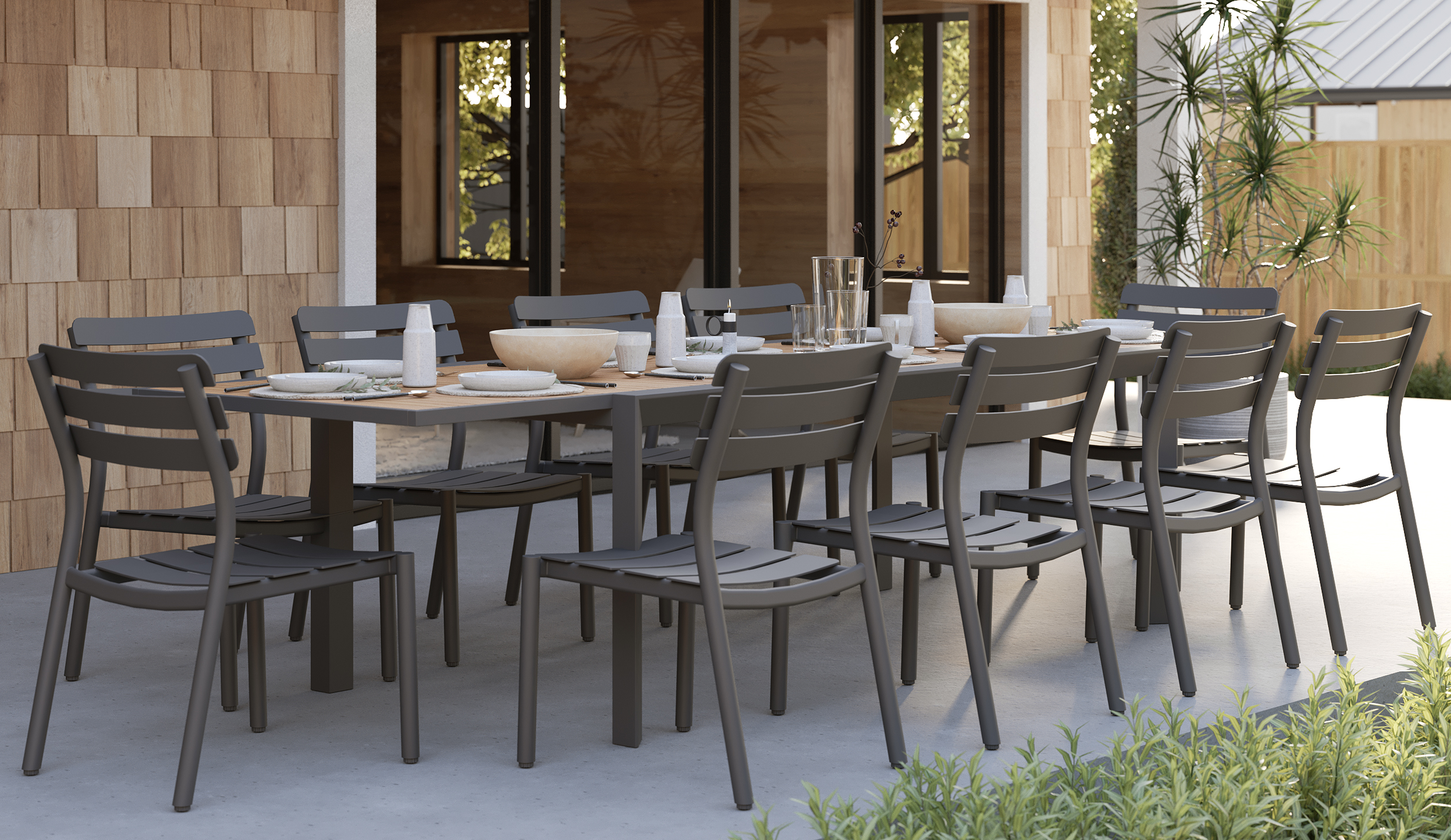 outer-Teak + Aluminum Outdoor Expandable Dining Table + 10 595 Armless Chairs-top down view of long rectangular outdoor expandable dining table set styled for a shared meal with teak tabletop, charcoal aluminum armless chairs, tableware and greenery on modern patio
