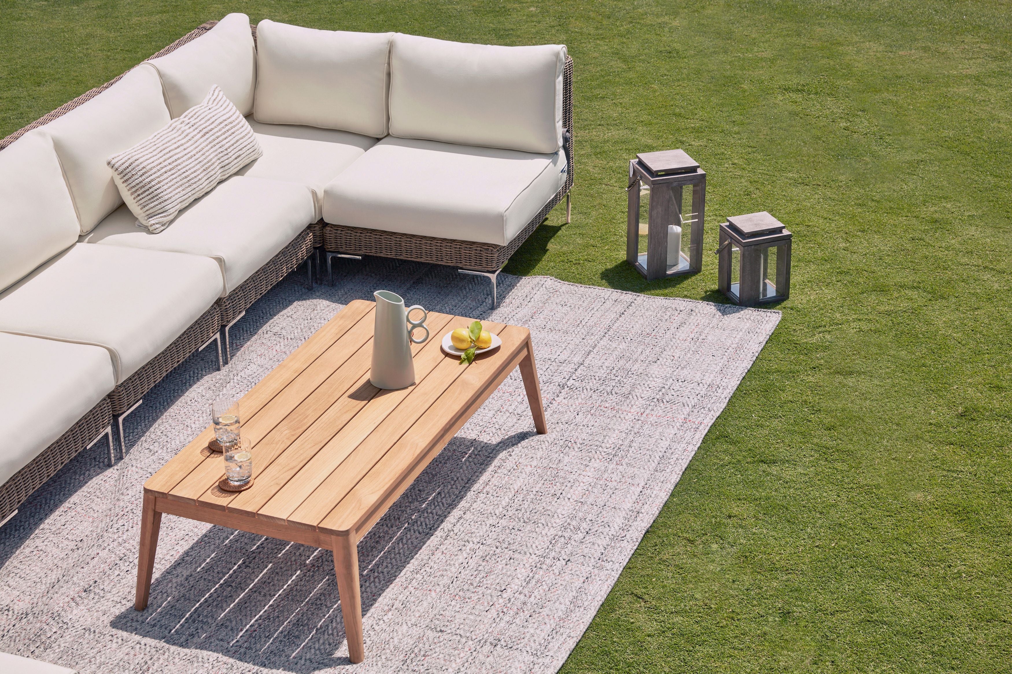 Eco friendly tapered leg teak outdoor coffee table shown on the seashell gray outdoor rug with the all-weather wicker sofa. #title_default title
