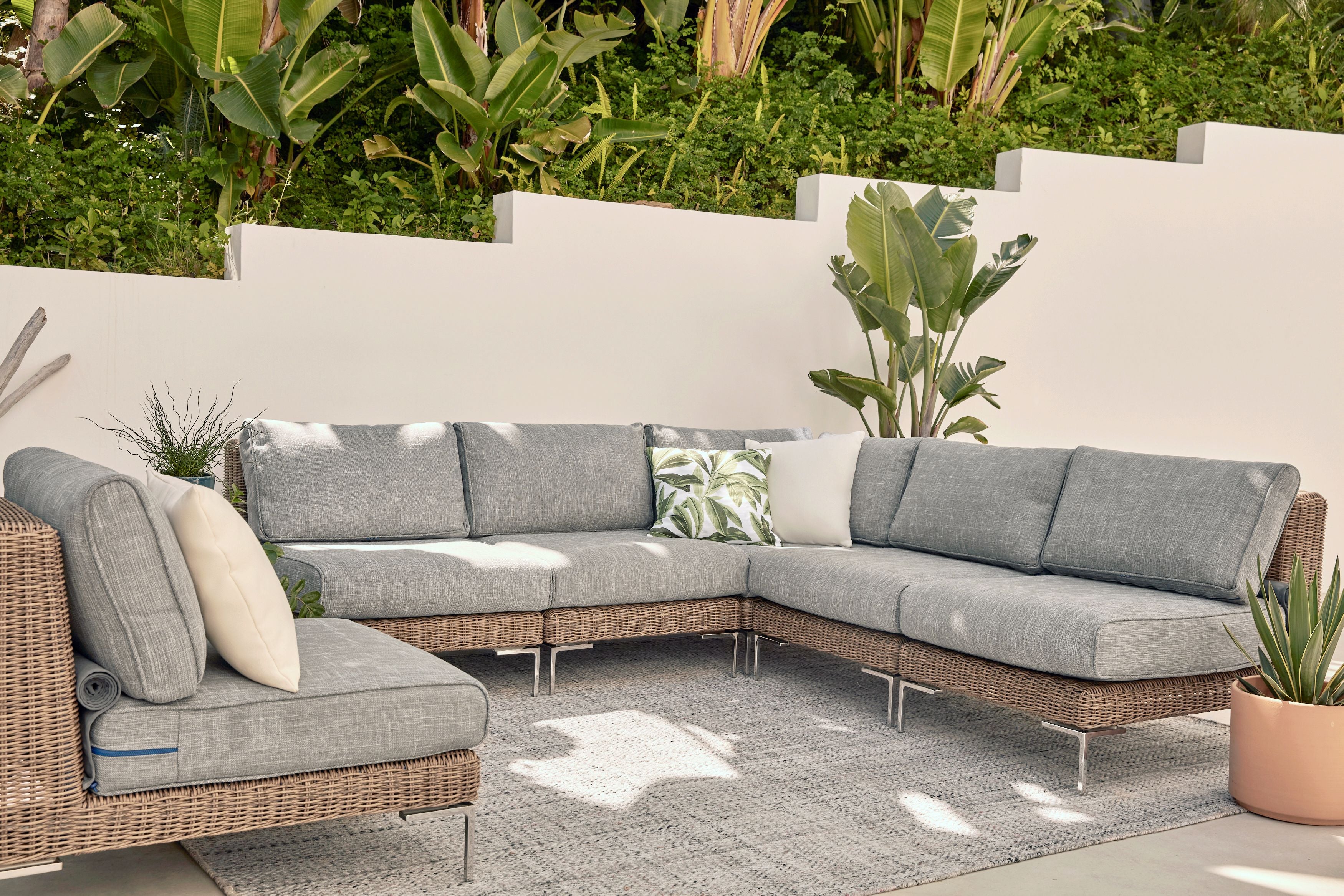 The luxurious all-weather wicker outdoor sectional with durable, sustainable outdoor rug.