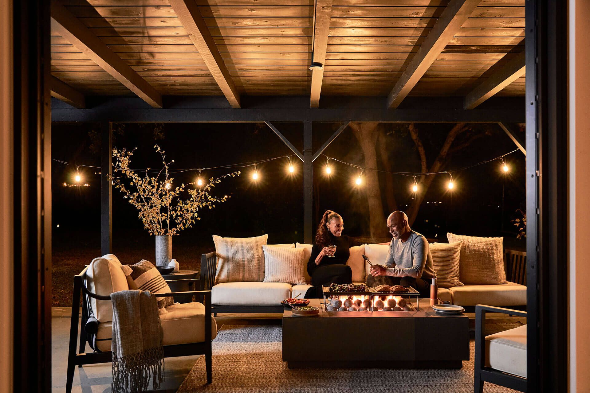 Outdoor Fire Pit Table being enjoyed by a couple at night.
