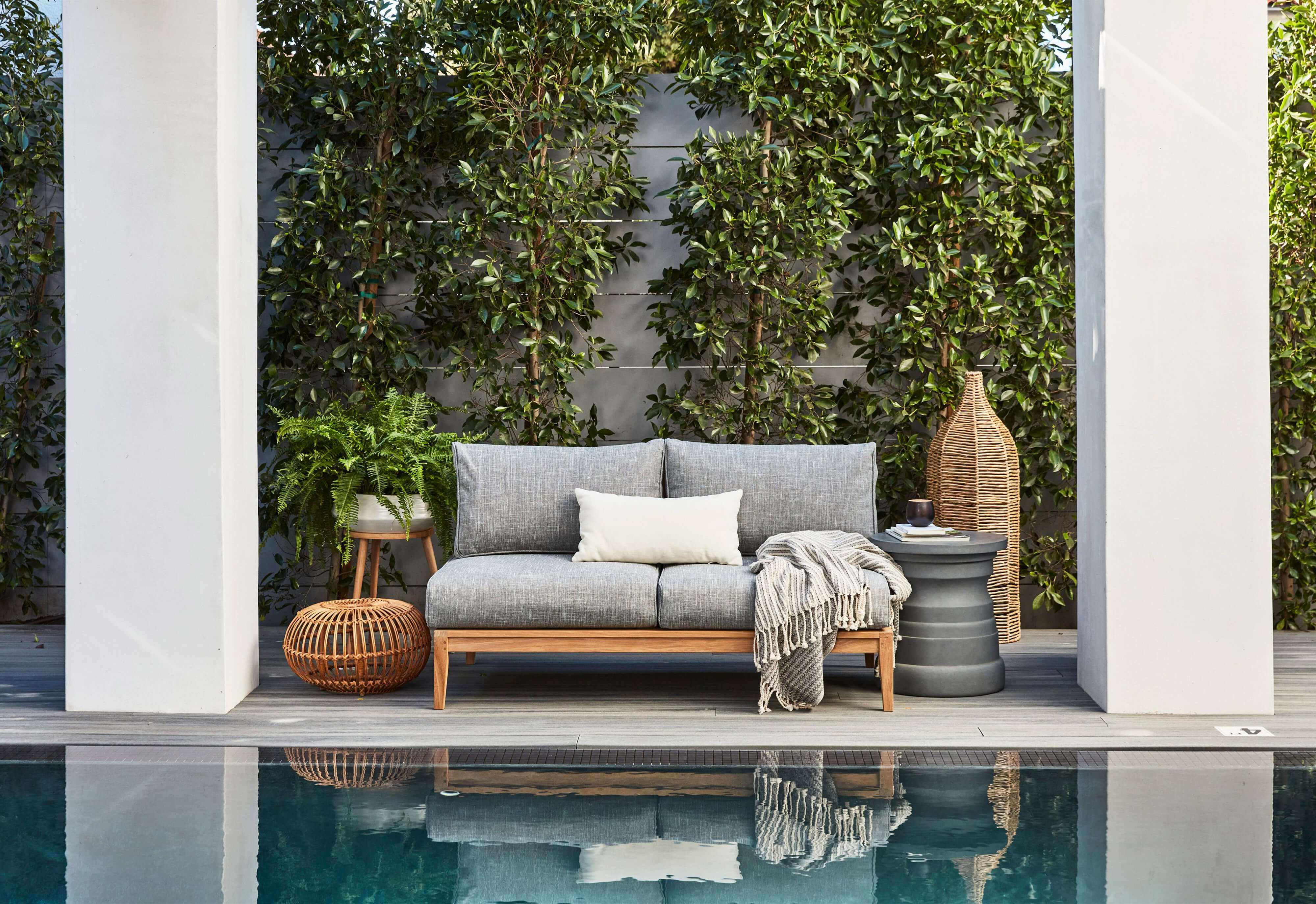 The gray Tiered Concrete Outdoor Side Table coupled with the teak armless loveseat. #table color_gray