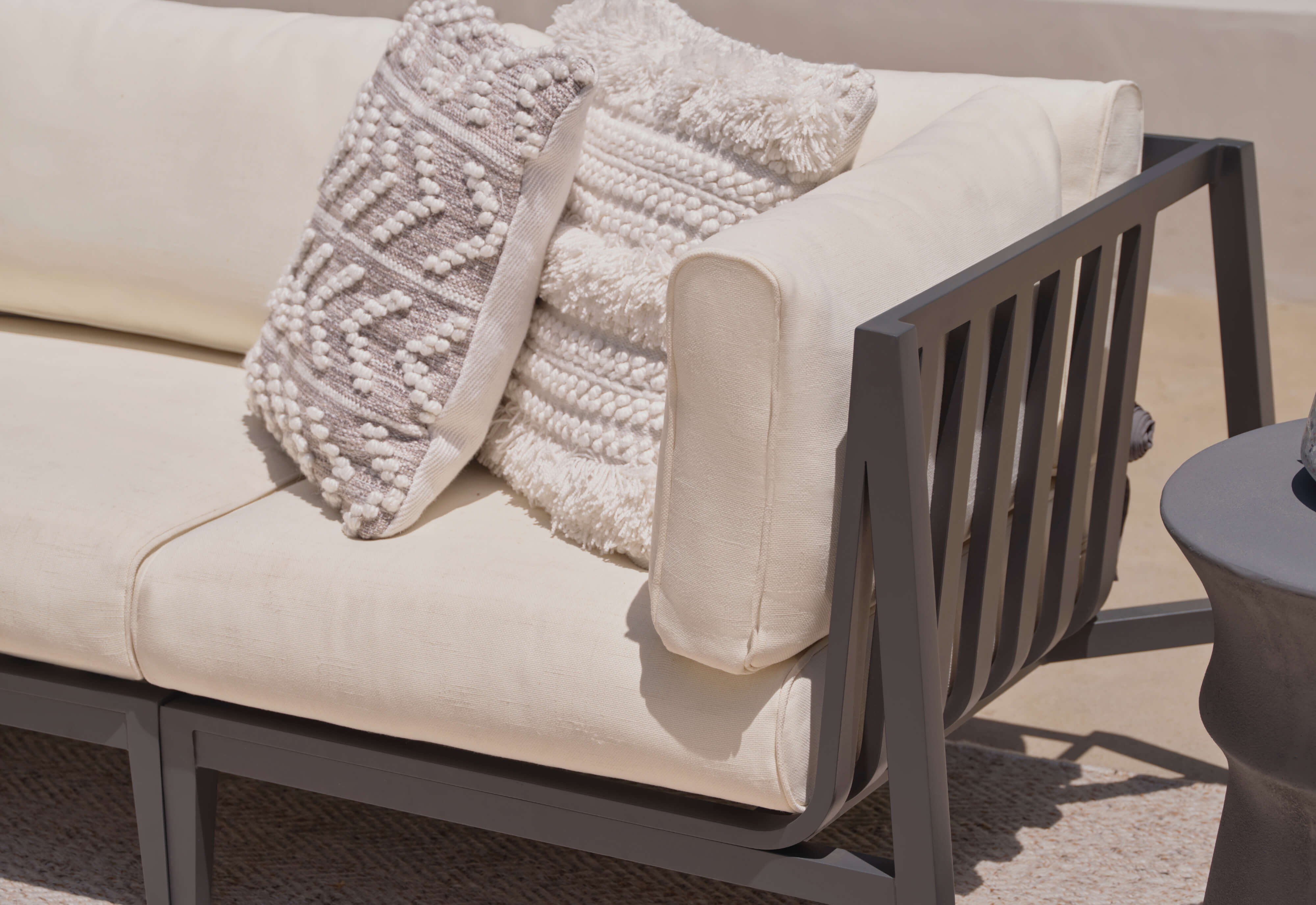 Charcoal aluminum loveseat with palisades cream cushions at an angle. #color_palisades cream