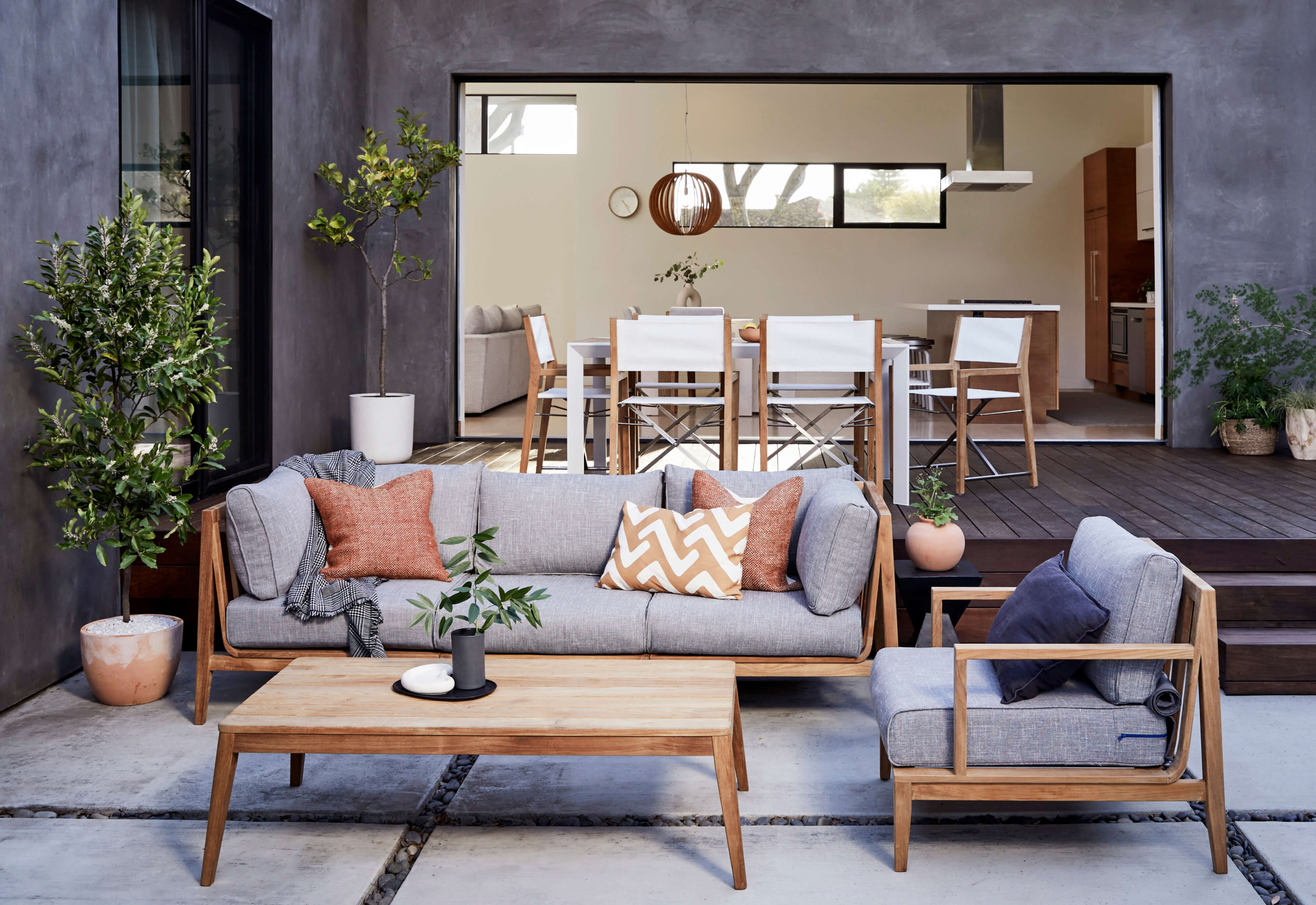 Teak outdoor 3-piece sofa with armchair and pacific fog gray cushions. Shown with the teak tapered leg outdoor coffee table. FSC Certified.
