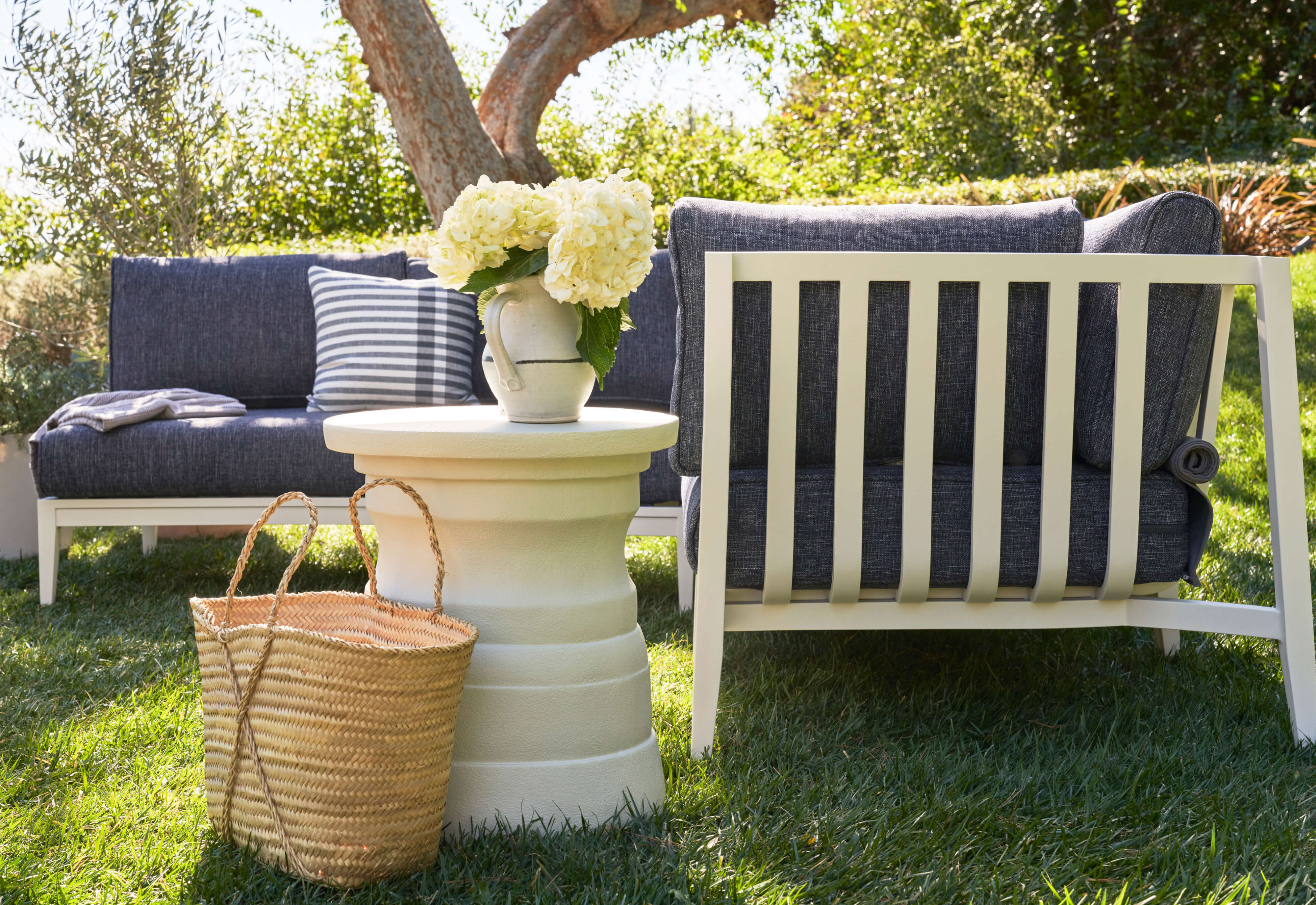 The white Tiered Concrete Outdoor Side Table coordinated with our white aluminum sofa with navy fabric. #table color_(unavailable) white