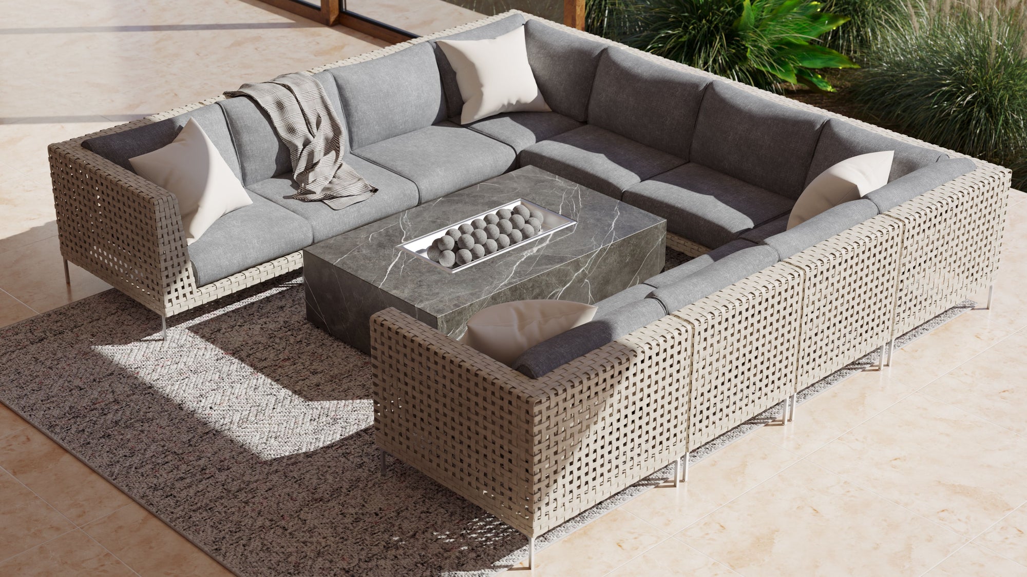 Outdoor sectional arranged around a fire pit on a textured rug