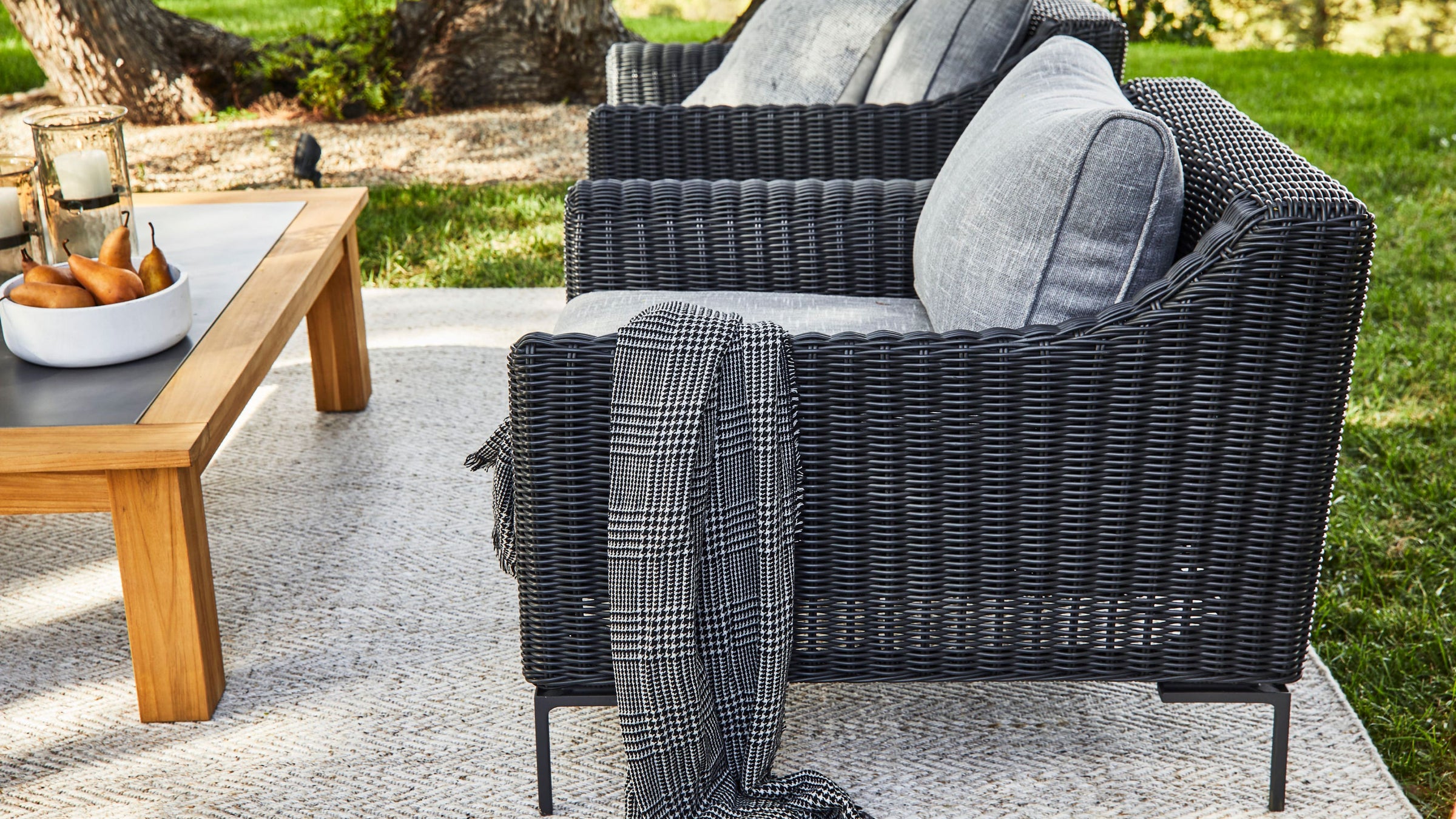 Lightweight outdoor throw blanket draped over patio wicker furniture