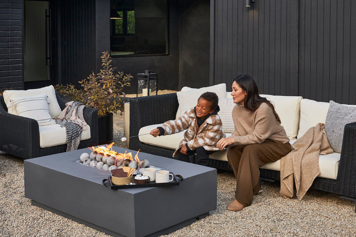 Outer outdoor sofa and lounge chairs placed around a rectangular gas fire pit