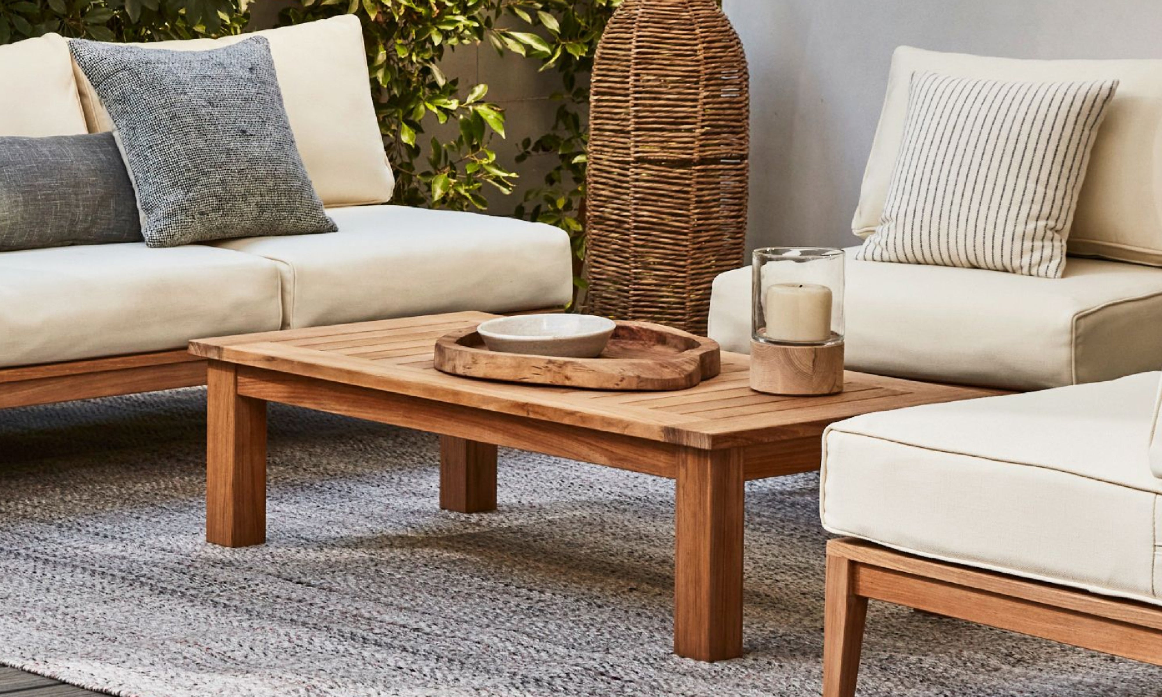 Outer teak outdoor coffee table with cushioned lounge seating in cozy patio conversation setting
