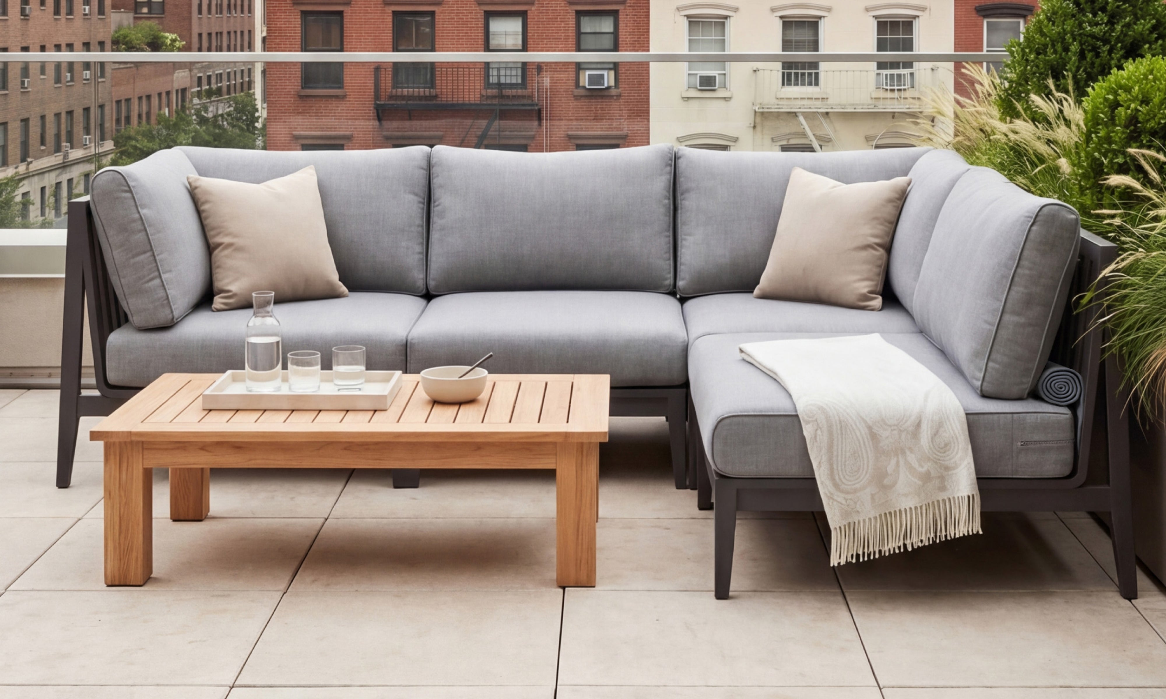 Outer teak outdoor coffee table with sectional sofa on stylish city rooftop terrace lounge