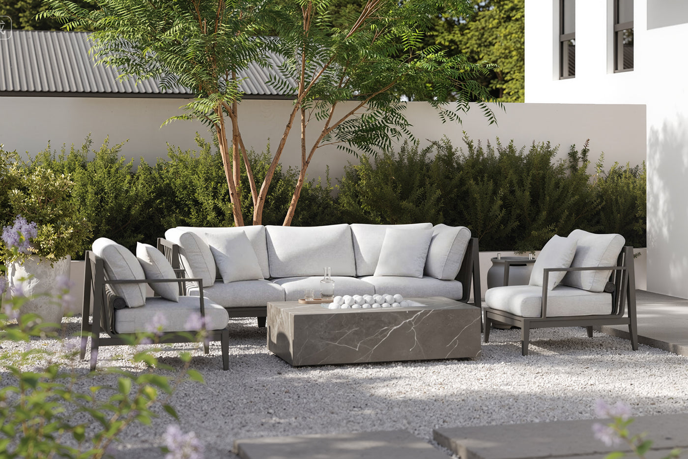 Outdoor sofa and armchairs arranged around a rectangular Outer fire pit on a modern patio