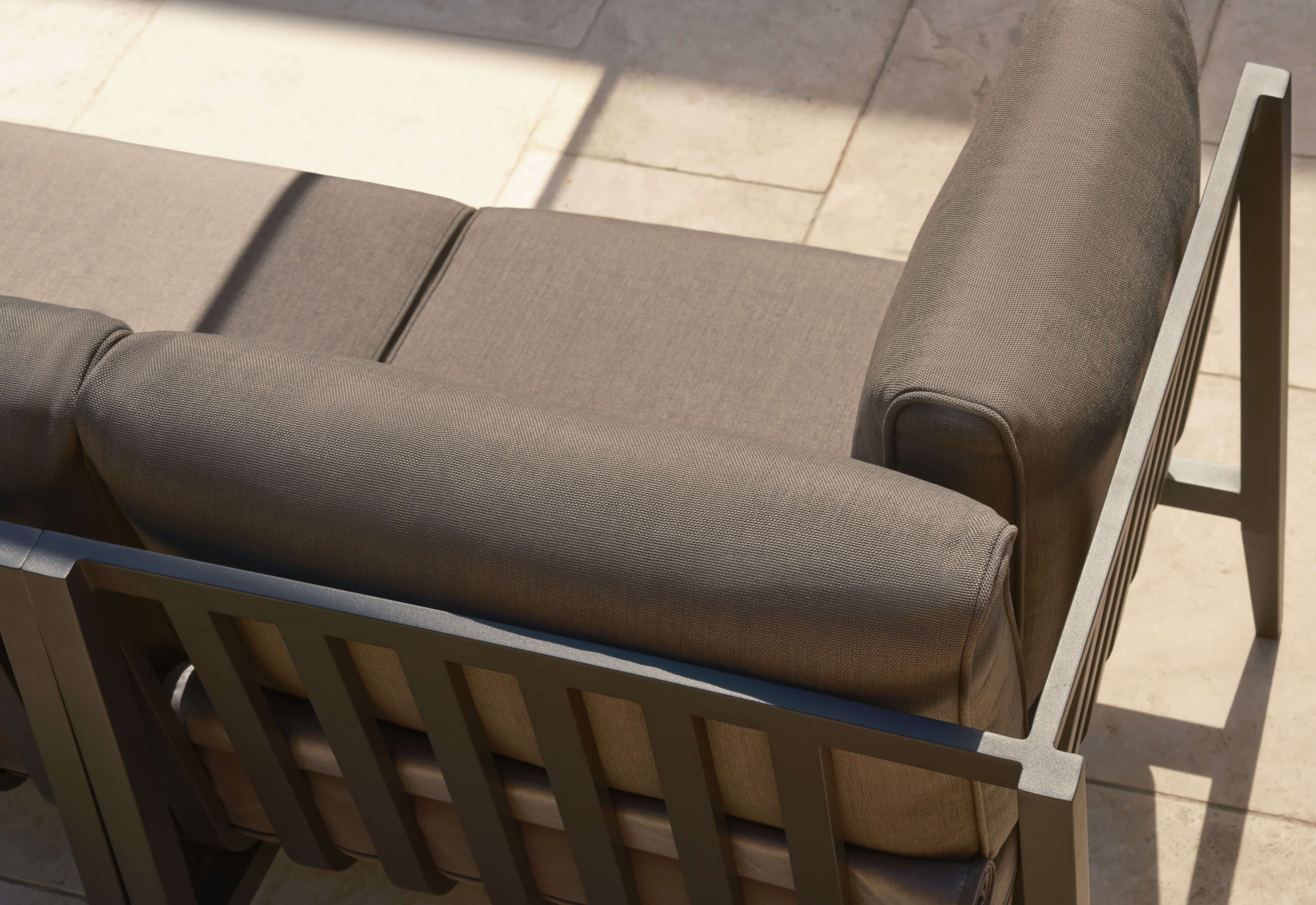 Top view of the charcoal aluminum sofa with dark pebble gray cushions. 