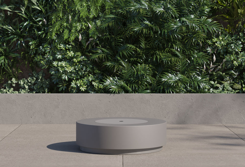 Round concrete fire pit table with burner lid cover closed functioning as an outdoor coffee table.