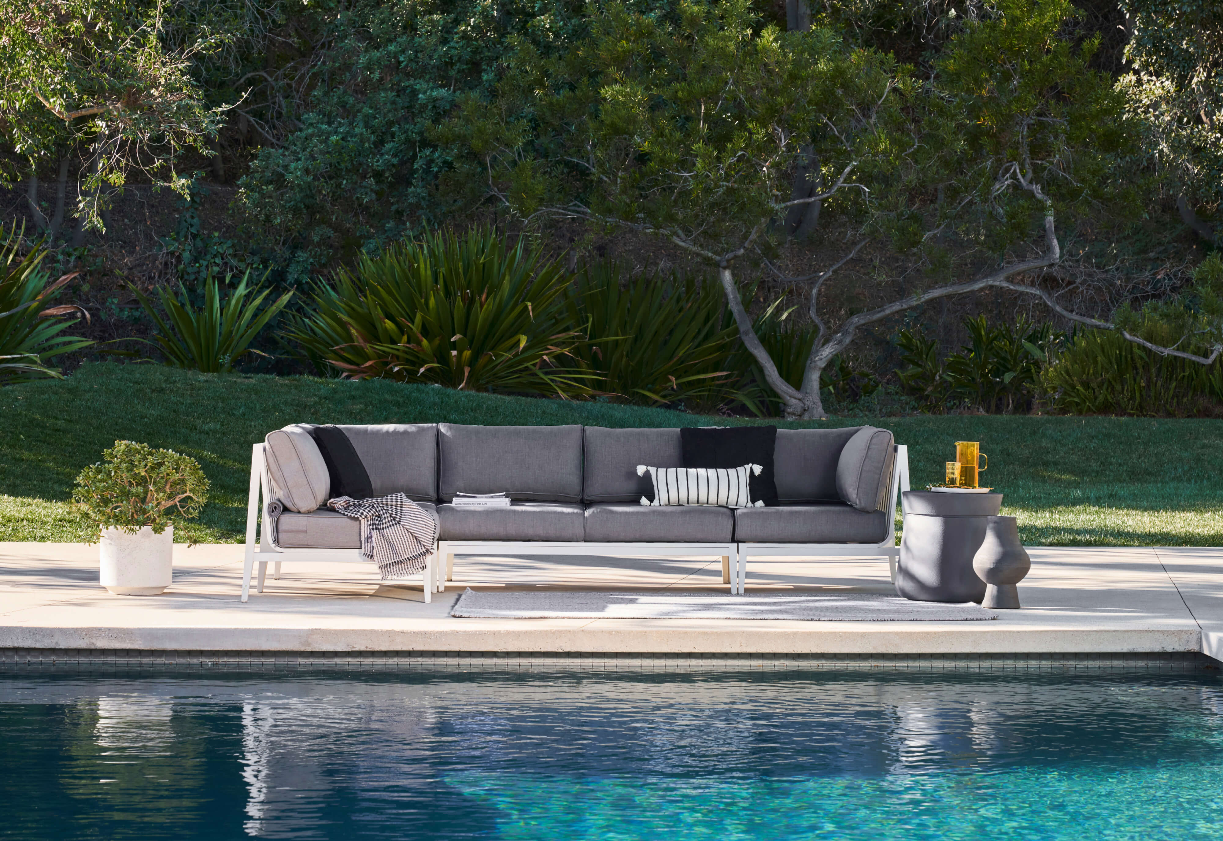 The 4-piece white aluminum sofa with pacific fog gray cushions and concrete side table.