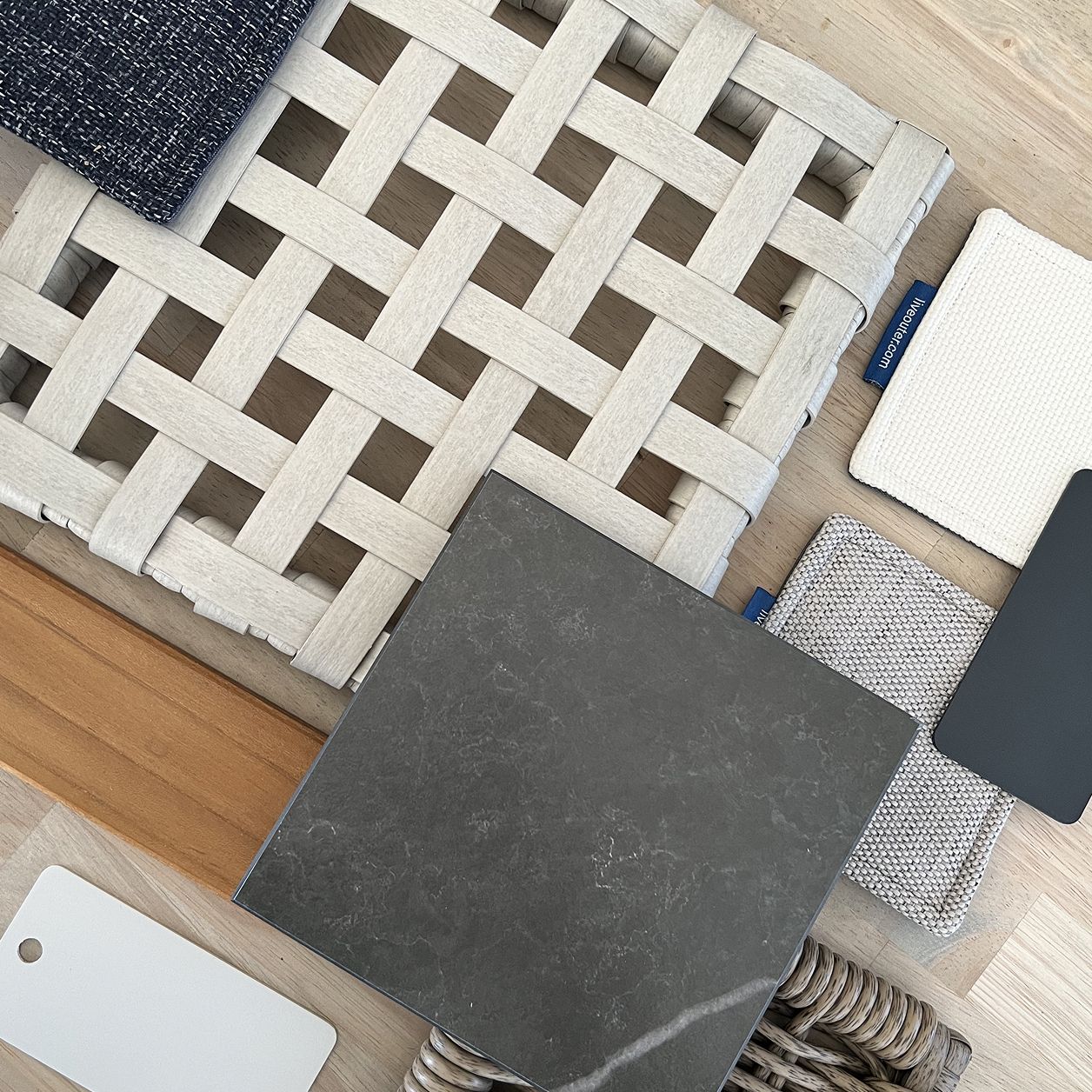 Outer outdoor furniture material samples including woven seating, fabrics, and finishes
