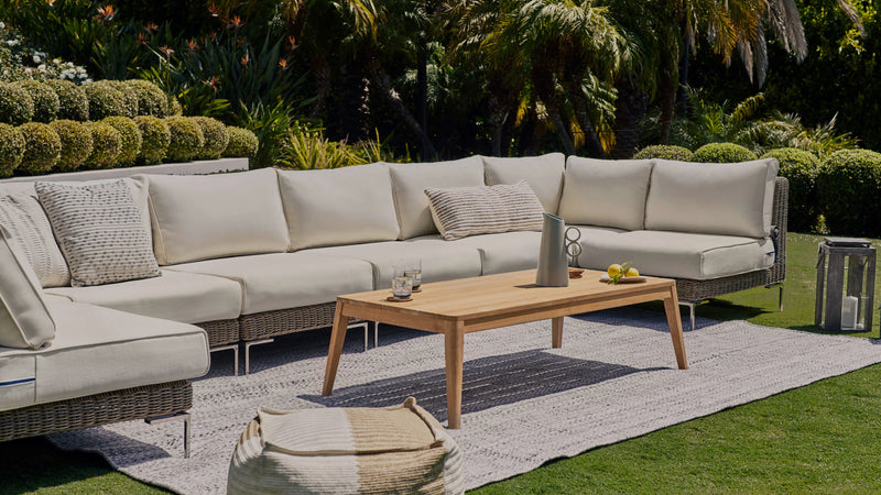 Handwoven all-weather wicker Outer sectional sofa on a garden patio